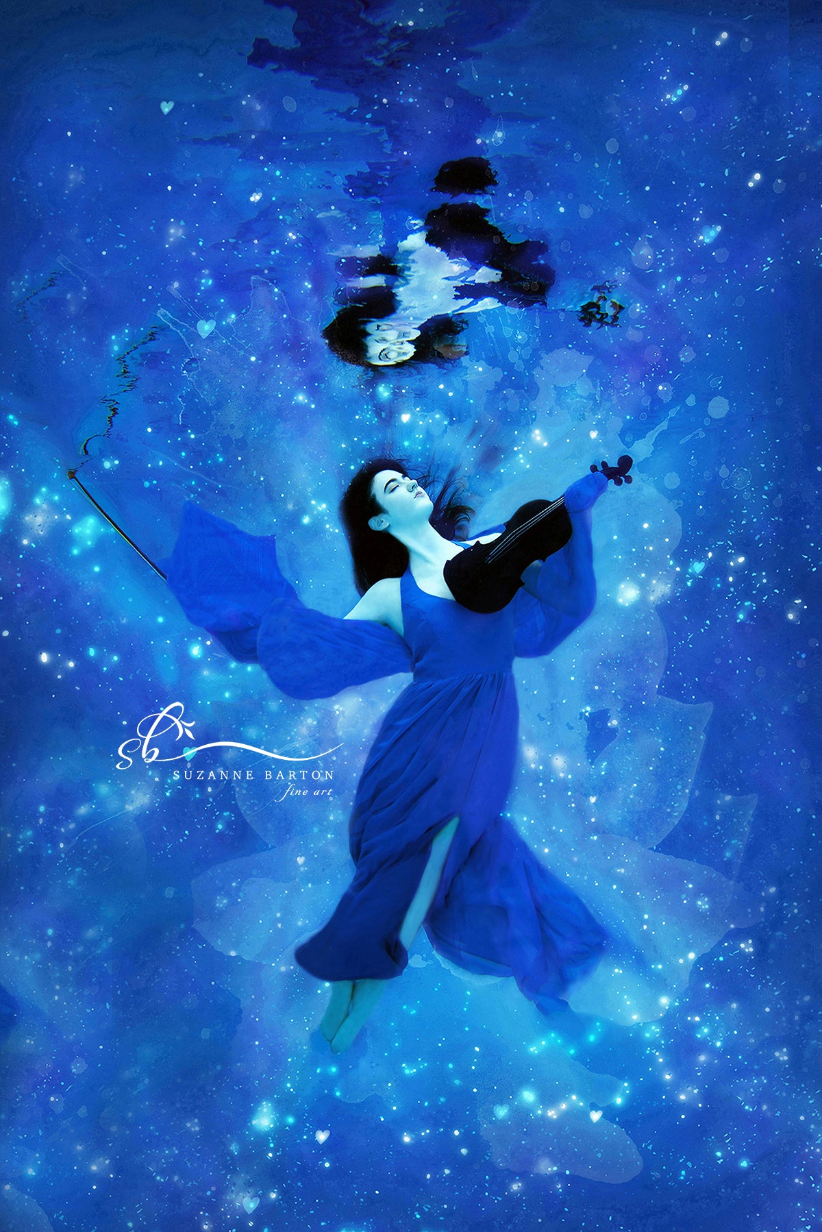 Magical looking beautiful dark haired woman in a blue dress underwater holding a violin.