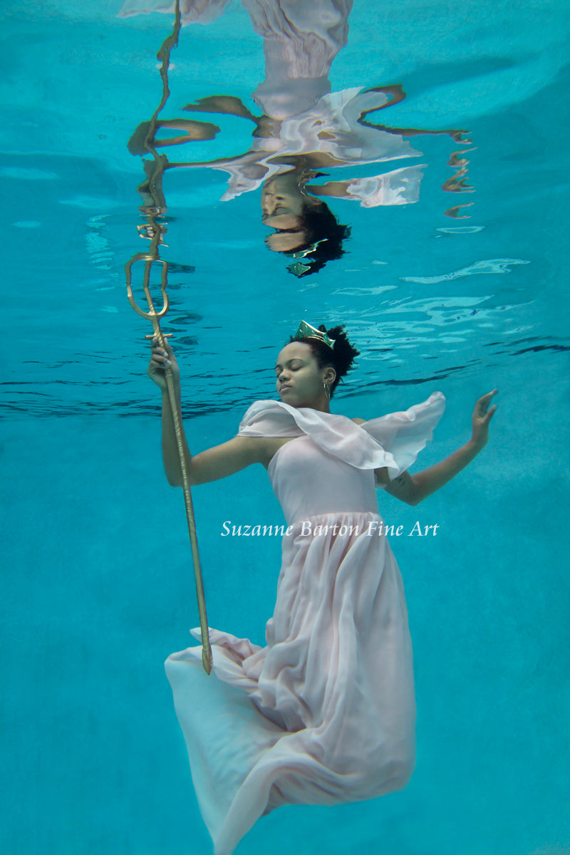 Beautiful underwater maiden in pink gown wearing a crown and holding a gold trident.