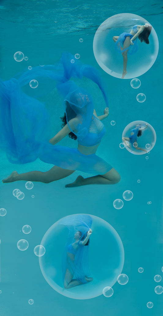 Dreamlike image of women dancing underwater surrounded by magical looking bubbles. A blue scarf floats gracefully with each dancer.