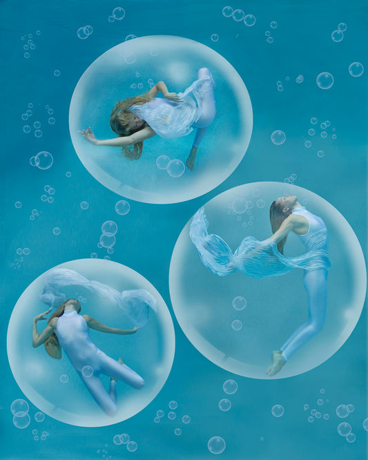 Three beautiful women positioned in elegant dancer poses while floating underwater in magical bubbles. 