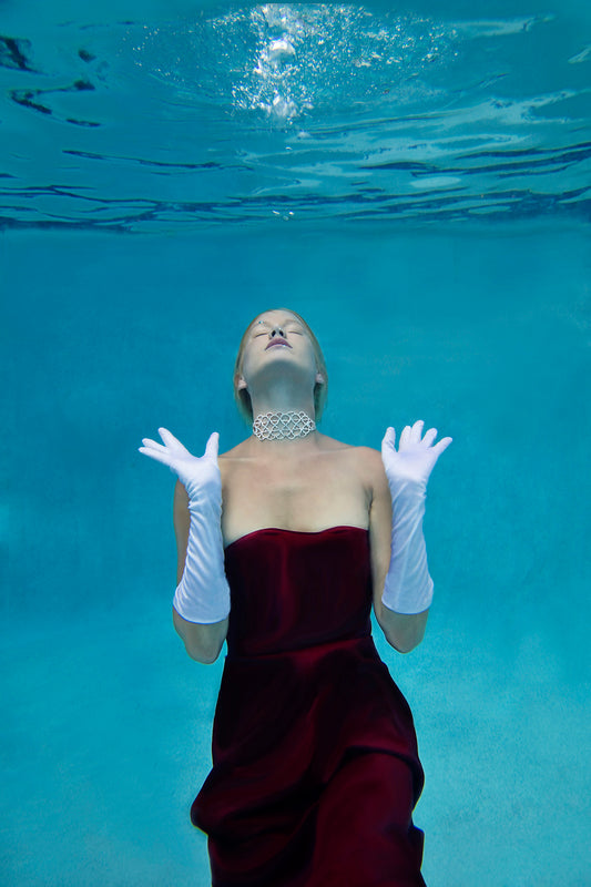 Bejeweled is an image of a beautiful woman in a gorgeous black gown, diamond necklace and white long gloves captured in an ethereal underwater setting.