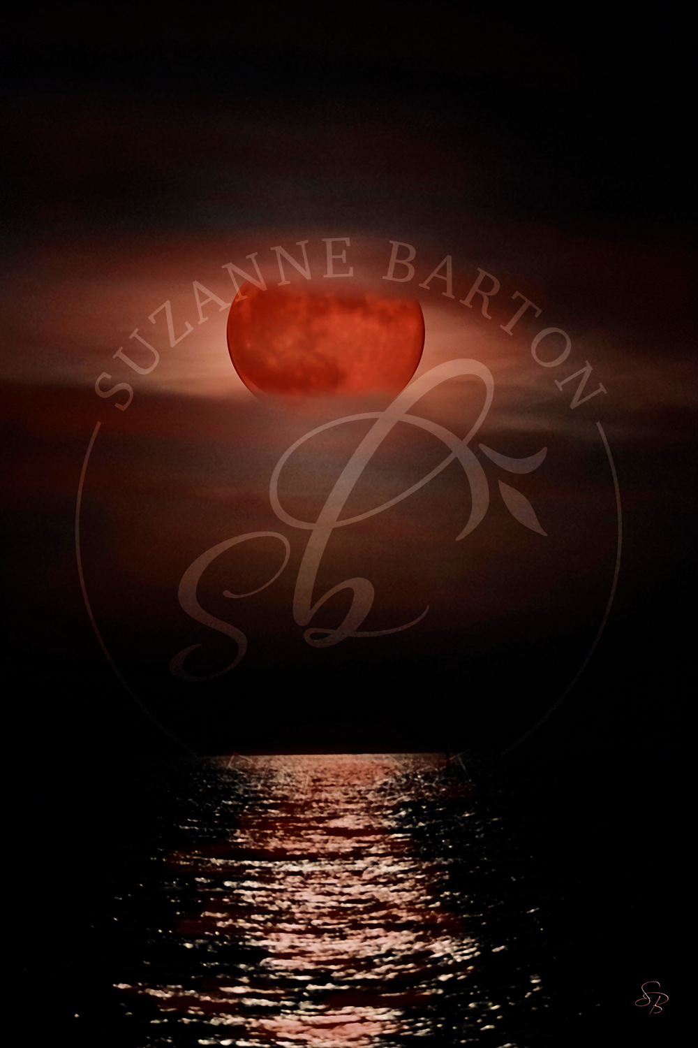 Stunning and paintery large blood orange moon over the ocean reflecting in the water.