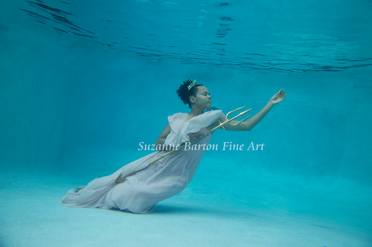 Beautiful ethereal underwater image of Atlantean princess wearing a pink gown and holding a trident.