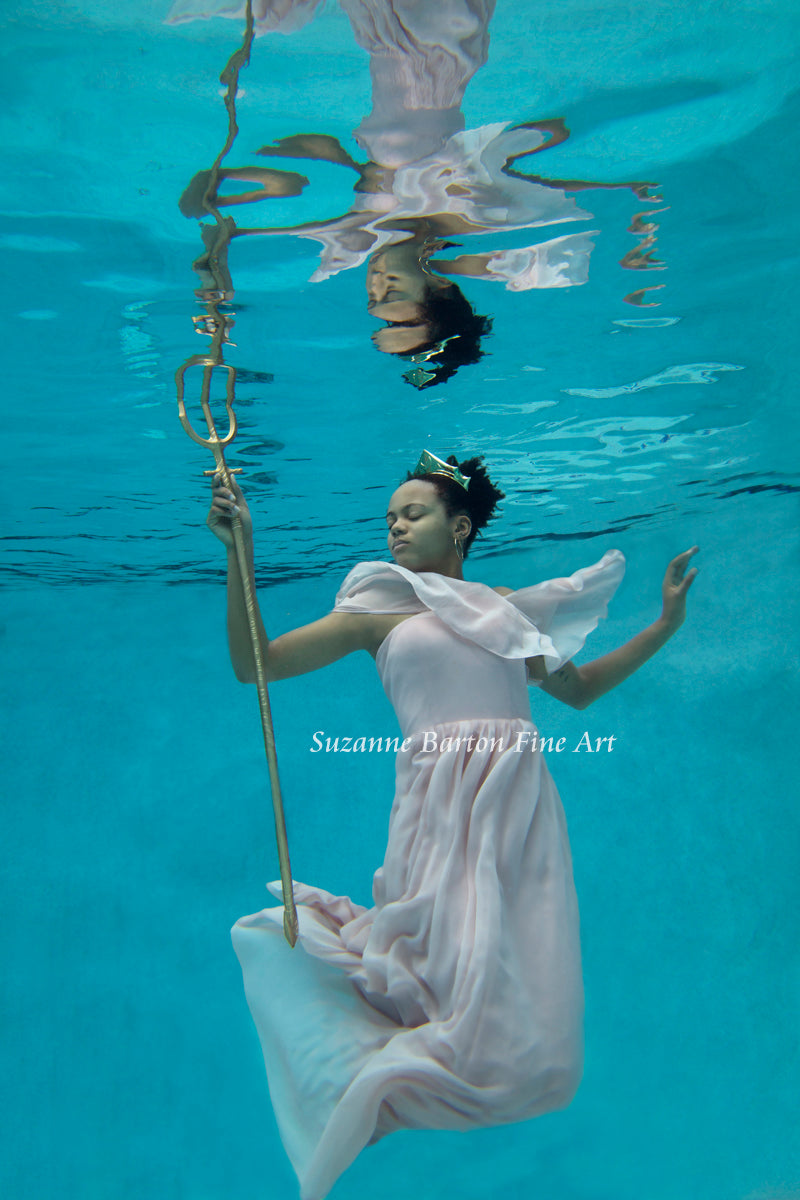 Beautiful underwater maiden in pink gown wearing a crown and holding a gold trident. 